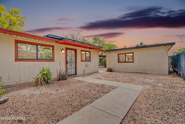 ranch-style house featuring fence