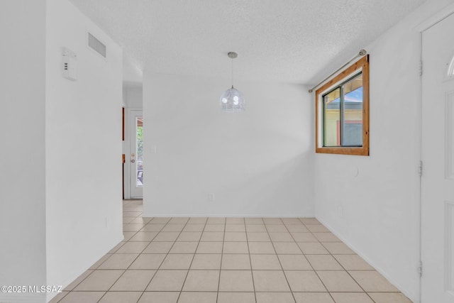 empty room with visible vents, baseboards, and a textured ceiling