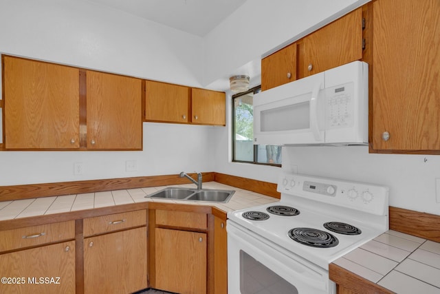 kitchen featuring a sink, tile countertops, and white appliances