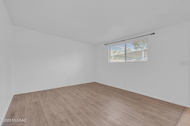 empty room with light wood-style floors and baseboards