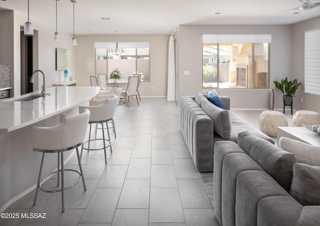 6949 W Tanner Trl, Marana, AZ 85658 - living room with light tile patterned floors, plenty of natural light, a notable chandelier, and baseboards