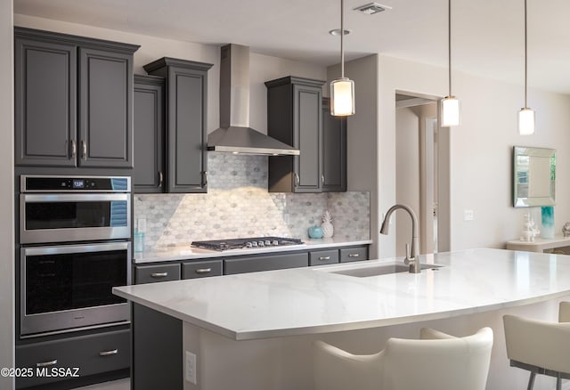 6949 W Tanner Trl, Marana, AZ 85658 - kitchen featuring stainless steel appliances, a sink, a breakfast bar area, wall chimney range hood, and backsplash