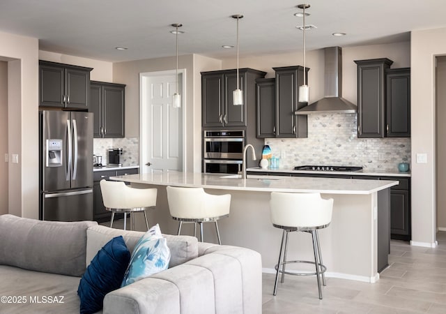 6949 W Tanner Trl, Marana, AZ 85658 - kitchen with open floor plan, light countertops, stainless steel appliances, a breakfast bar, and wall chimney exhaust hood