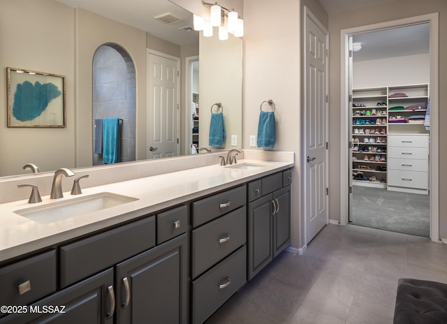 6949 W Tanner Trl, Marana, AZ 85658 - full bath featuring double vanity, a walk in closet, visible vents, and a sink