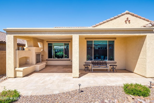 6949 W Tanner Trl, Marana, AZ 85658 - rear view of house featuring stucco siding, an outdoor fireplace, and a patio area