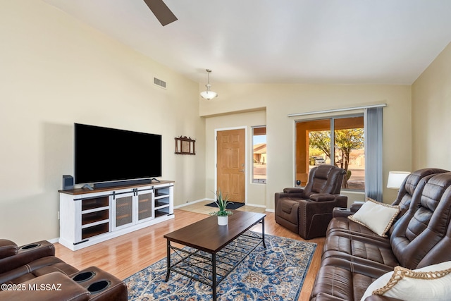 living area featuring visible vents, baseboards, ceiling fan, wood finished floors, and vaulted ceiling