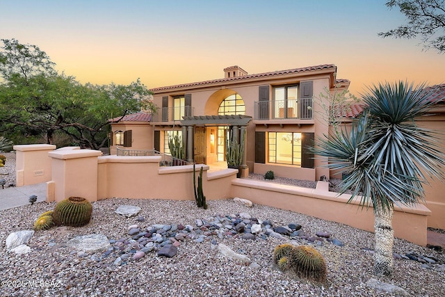 7222 E Desert Moon Loop, Tucson, AZ 85750 - view of front of home featuring a balcony, a fenced front yard, stucco siding, a tile roof, and a chimney