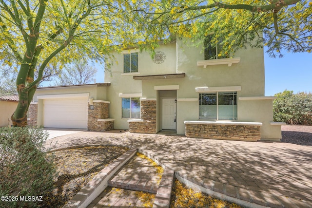 view of front facade featuring stone siding, a garage, and stucco siding