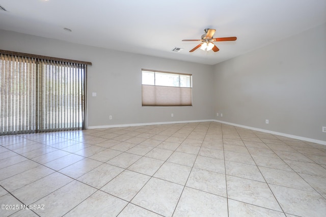 spare room with baseboards, a ceiling fan, visible vents, and light tile patterned floors