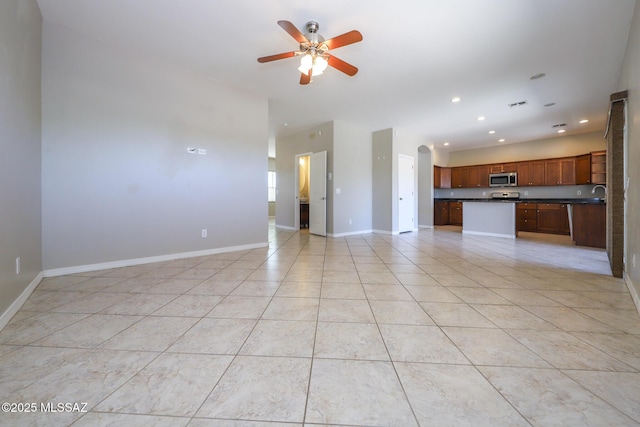 unfurnished living room with baseboards, a ceiling fan, light tile patterned flooring, and recessed lighting
