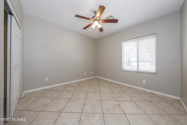 unfurnished room featuring baseboards, a ceiling fan, visible vents, and light tile patterned floors