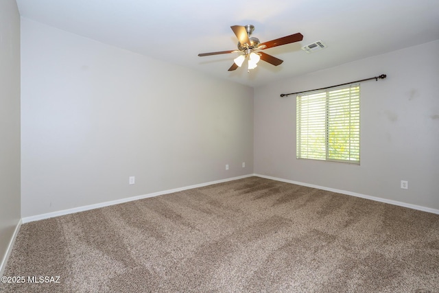 carpeted spare room with baseboards, a ceiling fan, and visible vents
