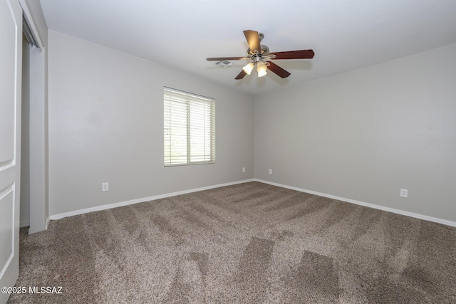 carpeted spare room featuring baseboards and ceiling fan