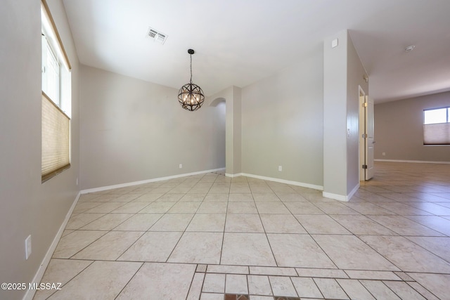 unfurnished room with baseboards, visible vents, an inviting chandelier, and light tile patterned floors