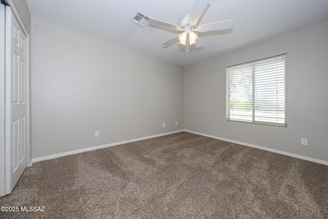 carpeted spare room with ceiling fan, baseboards, and visible vents