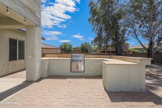 view of patio featuring fence, a grill, and area for grilling
