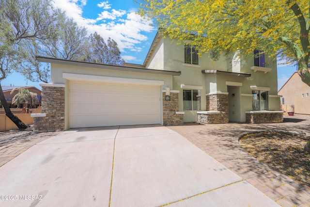 view of front of home with stucco siding, an attached garage, driveway, and stone siding