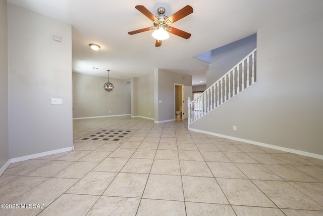 unfurnished living room with ceiling fan with notable chandelier, tile patterned floors, baseboards, and stairs