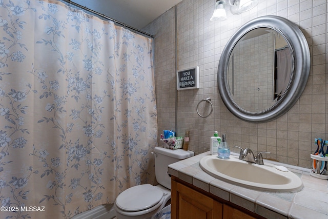 bathroom featuring a shower with curtain, toilet, vanity, and tile walls