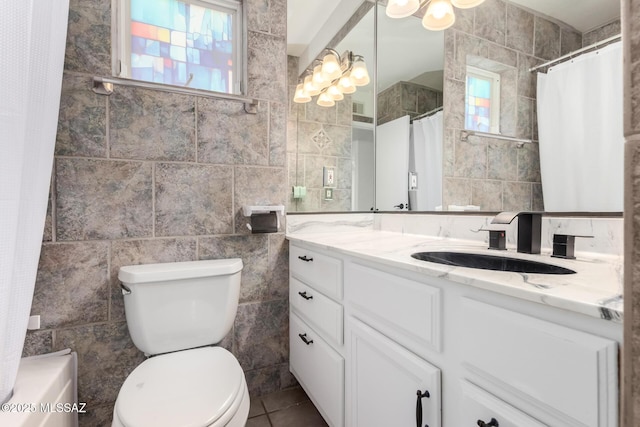 full bath featuring curtained shower, toilet, vanity, and tile walls