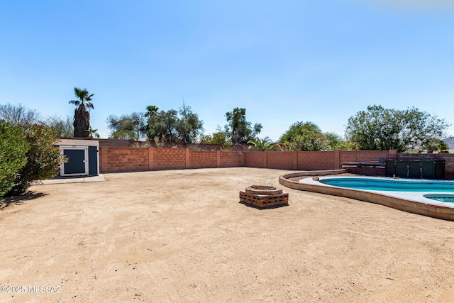 exterior space featuring a fenced in pool, fence, and an outdoor fire pit