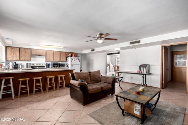 living room with light tile patterned flooring, visible vents, and ceiling fan