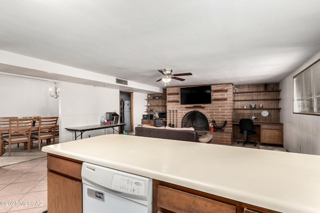 kitchen featuring light tile patterned flooring, visible vents, dishwasher, a ceiling fan, and a fireplace
