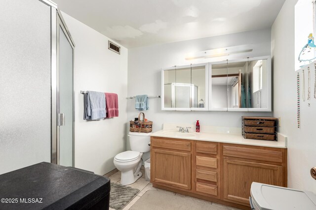 full bath featuring a stall shower, toilet, vanity, tile patterned flooring, and visible vents