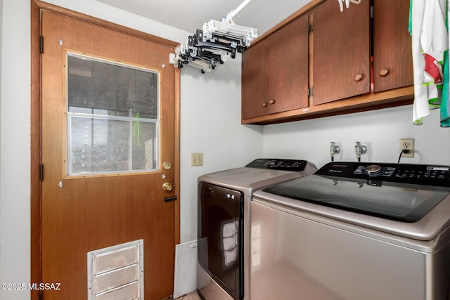 washroom with cabinet space and washer and dryer