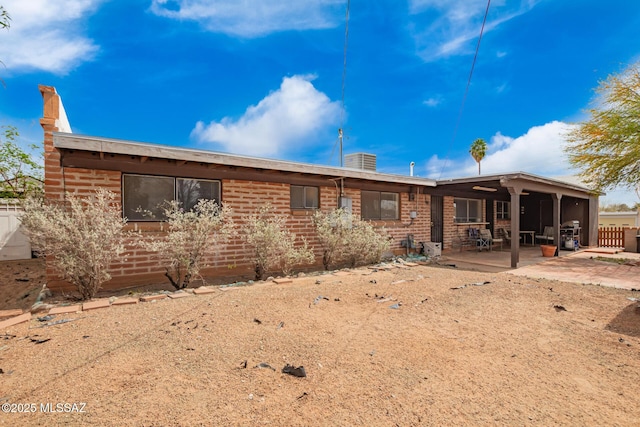 back of house with a patio, brick siding, and fence