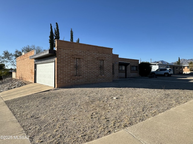 view of front of property with brick siding, driveway, and an attached garage