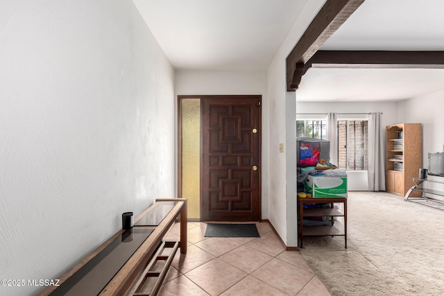foyer with beamed ceiling and light tile patterned floors