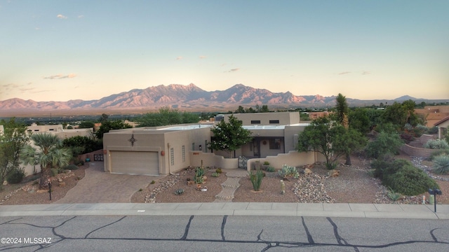 875 S Corte Monte Cristo, Green Valley, AZ 85614 - pueblo-style house with an attached garage, a mountain view, stucco siding, and decorative driveway