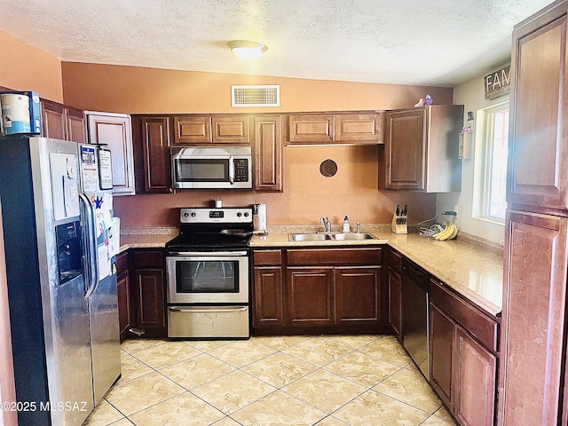kitchen with light tile patterned flooring, light countertops, visible vents, stainless steel appliances, and a sink