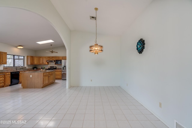 kitchen with arched walkways, appliances with stainless steel finishes, lofted ceiling, and visible vents