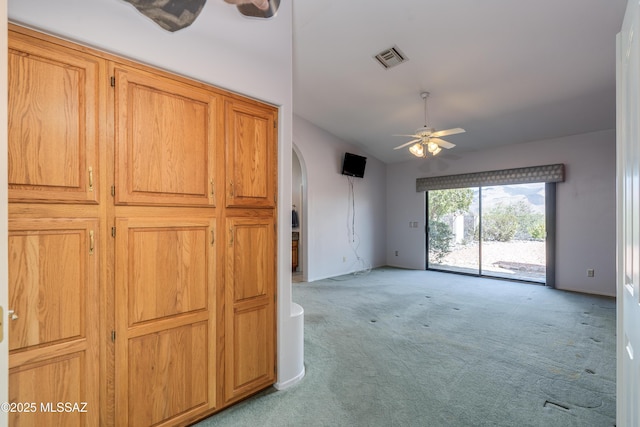 interior space featuring visible vents, arched walkways, a ceiling fan, light carpet, and lofted ceiling