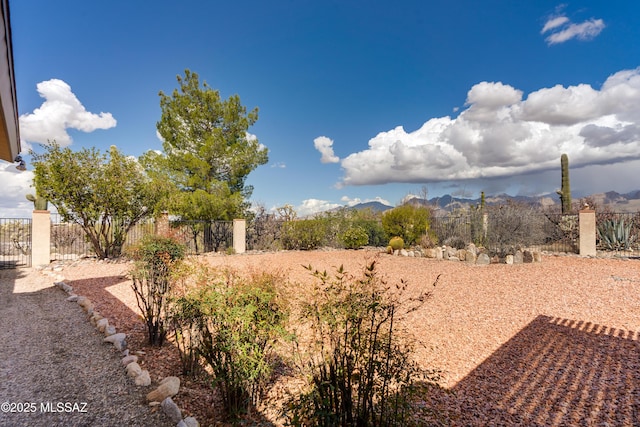 view of yard with a mountain view and fence