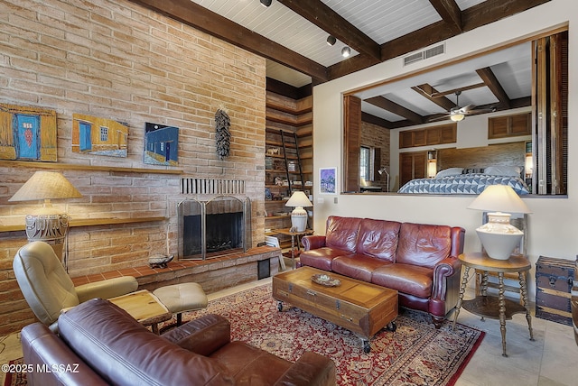 tiled living area with visible vents, a fireplace, a ceiling fan, beam ceiling, and brick wall