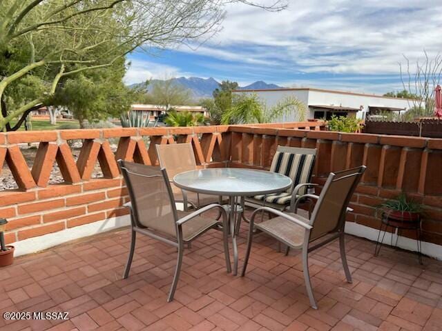 balcony with a patio area, a mountain view, and outdoor dining space