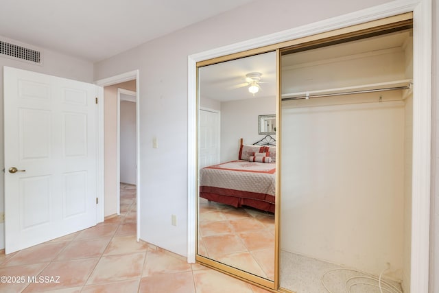 bedroom with visible vents, light tile patterned floors, and a closet