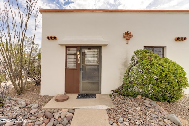 entrance to property with stucco siding