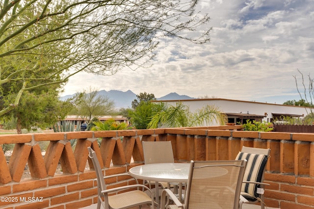 deck with a mountain view and outdoor dining area