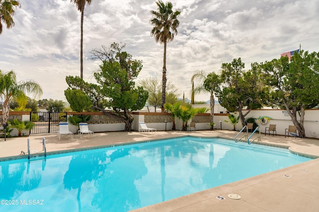 community pool featuring a patio and fence
