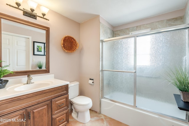 bathroom with vanity, tile patterned flooring, toilet, and shower / bath combination with glass door