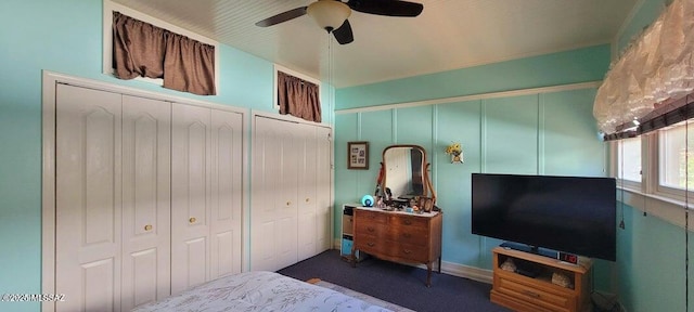 bedroom featuring two closets, a ceiling fan, and carpet