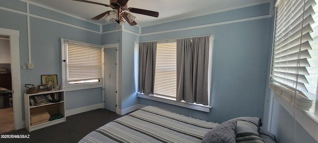 carpeted bedroom featuring baseboards, ornamental molding, and ceiling fan