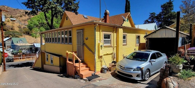 view of side of home with an outbuilding and a chimney