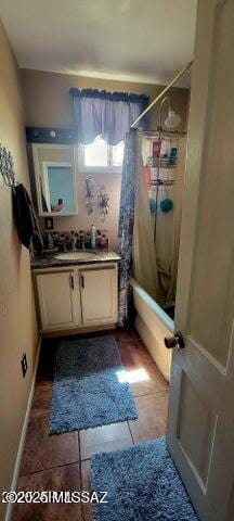bathroom featuring baseboards, shower / tub combo with curtain, tile patterned floors, and vanity