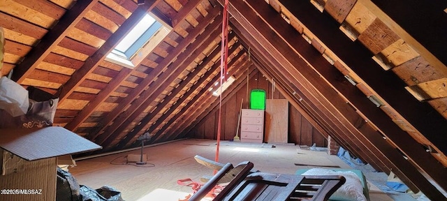 unfinished attic featuring a skylight