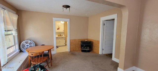 carpeted dining area featuring a textured ceiling